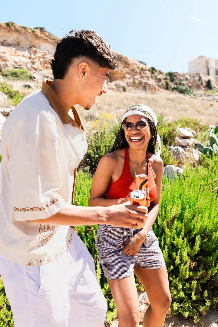 Twee vrienden met een blikje Kinnie in het Maltese landschap
